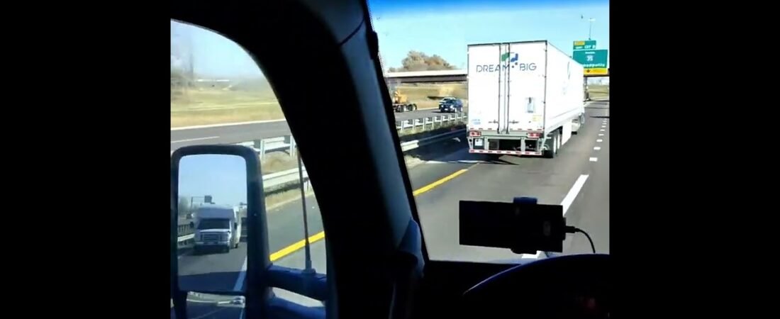 POV Inside of a moving semi truck driving on the highway fully loaded. (2)
