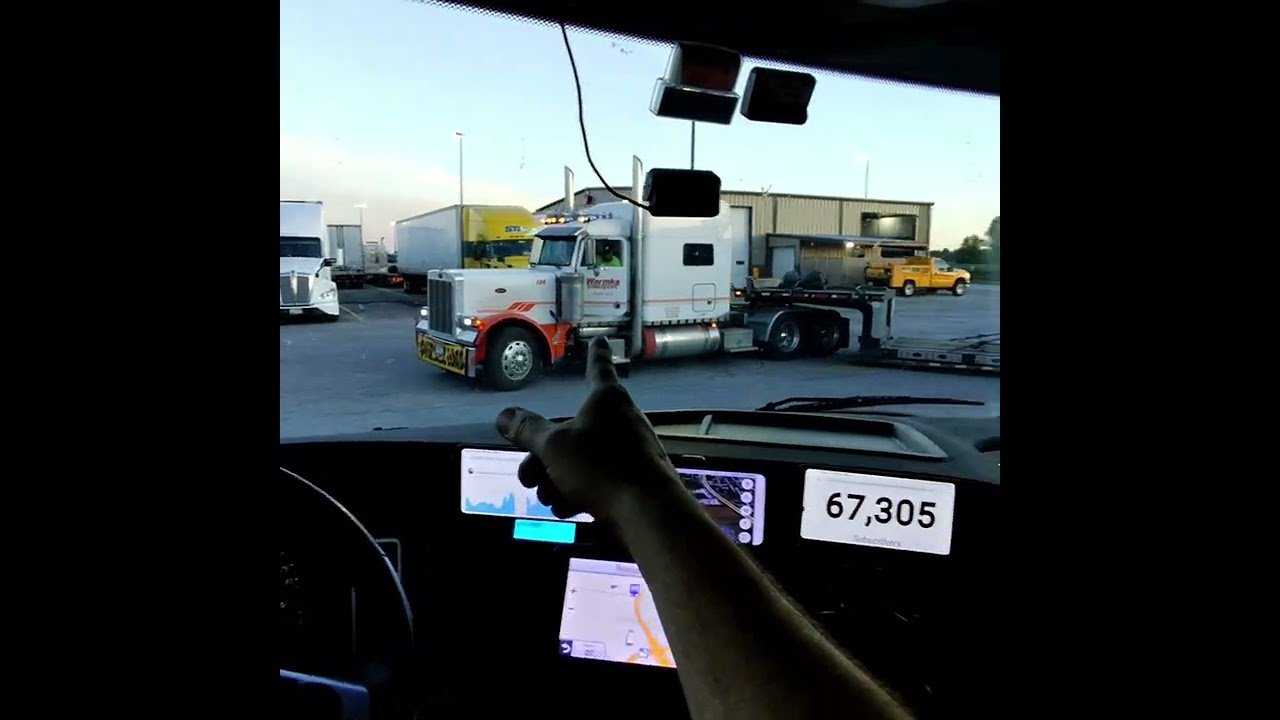 Trucker almost falls out of his truck while backing with his door open. This is an OSHA Violation!